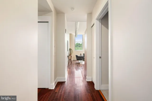 a view of hallway with wooden floor and a window