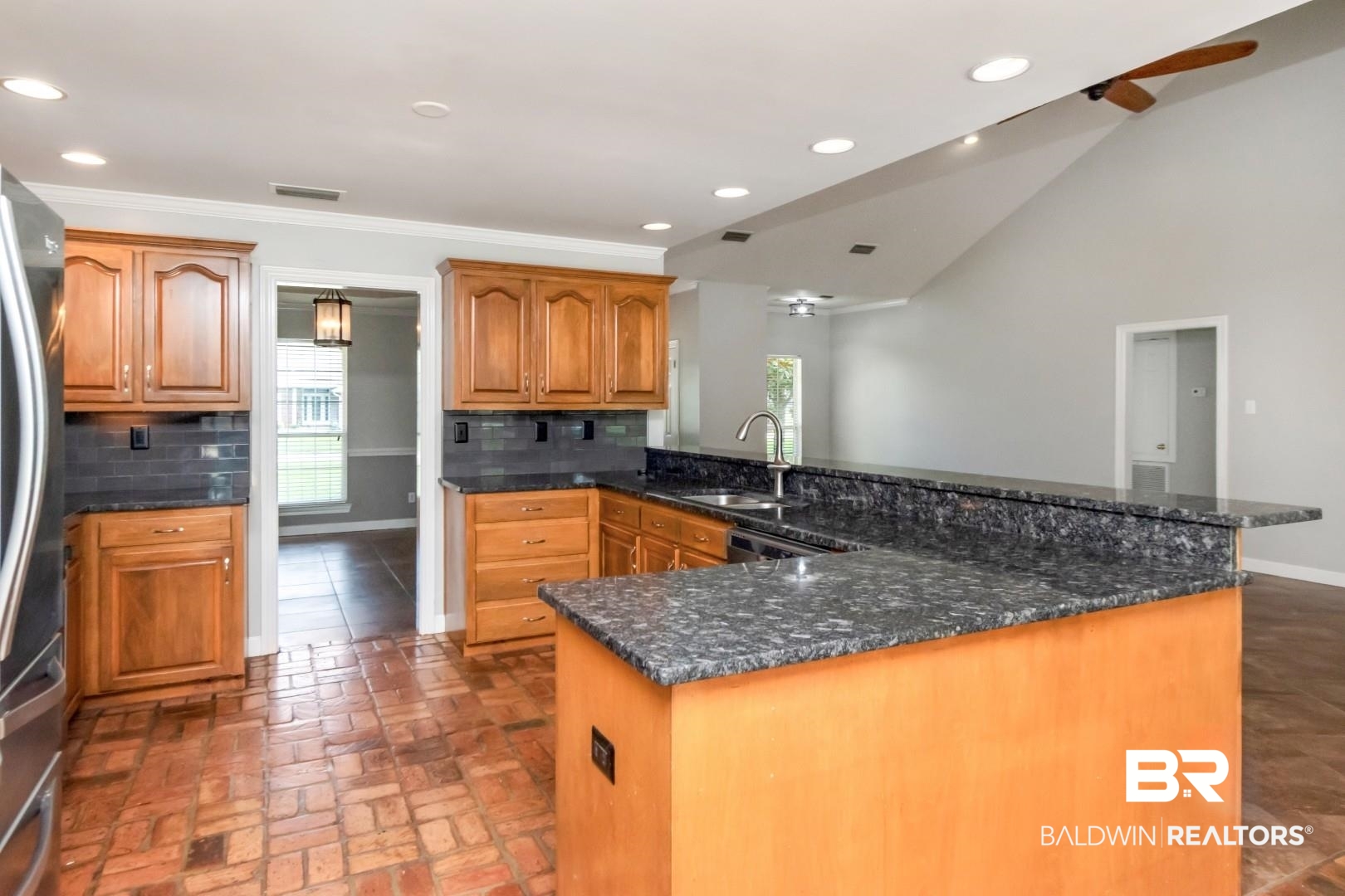 10691 Hunters Ridge Drive Mobile, AL 36695 - Photo 11 of 37 Kitchen featuring wood cabinetry, dark granite countertops, and a subway tile backsplash
