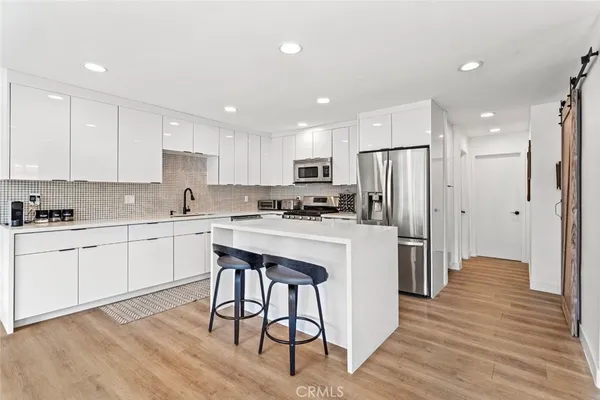 a kitchen with white cabinets and refrigerator
