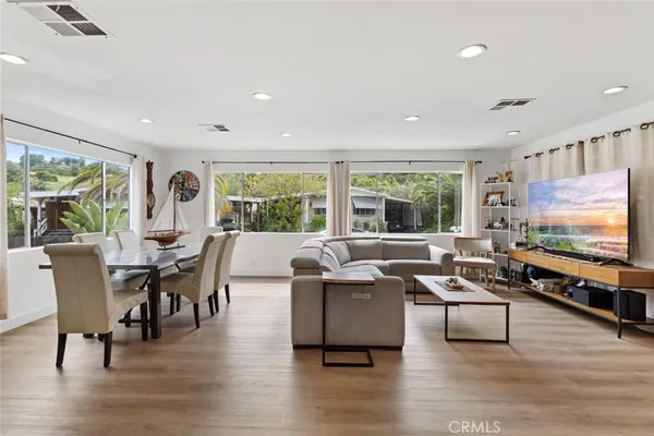 a living room with furniture flat screen tv and a large window