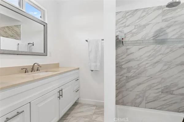 a bathroom with a granite countertop sink and a mirror