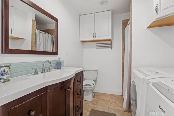 a bathroom with a sink a toilet and a mirror