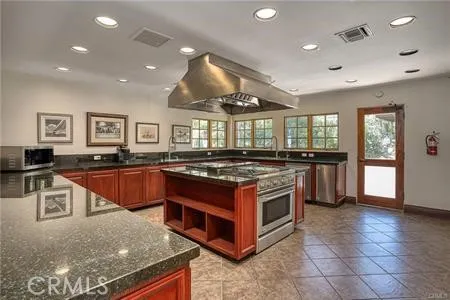 a large kitchen with stainless steel appliances granite countertop a stove and a sink