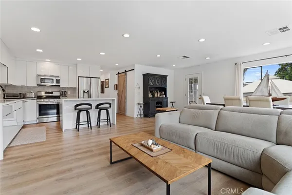 a living room with furniture and kitchen view
