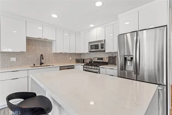 a kitchen with stainless steel appliances a refrigerator stove microwave and sink