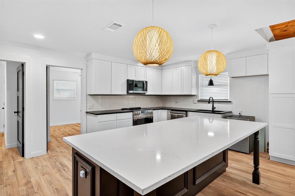 621 Craft Road Bells, TX 75414 - Photo 11 of 40 a kitchen with kitchen island granite countertop a sink a stove and a wooden floors