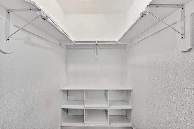 a view of a room with wooden floor ceiling fan and windows