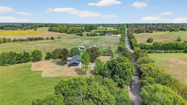 an aerial view of a house with a yard and trees