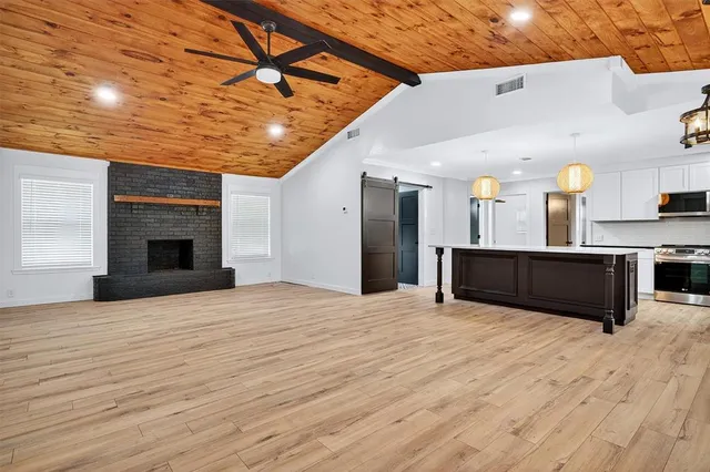 a view of empty room with wooden floor and fireplace