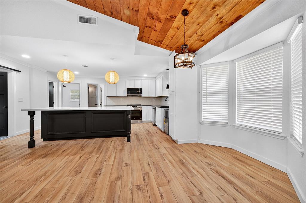 621 Craft Road Bells, TX 75414 - Photo 10 of 40 a kitchen with stainless steel appliances kitchen island granite countertop a refrigerator a sink dishwasher a stove and white countertops with wooden floor