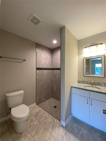 a bathroom with a toilet a sink and glass door