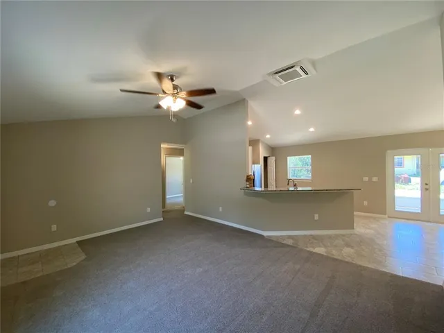 an empty room with a ceiling fan and a window