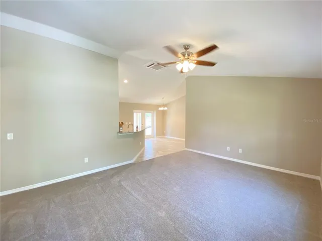 an empty room with a window and a ceiling fan
