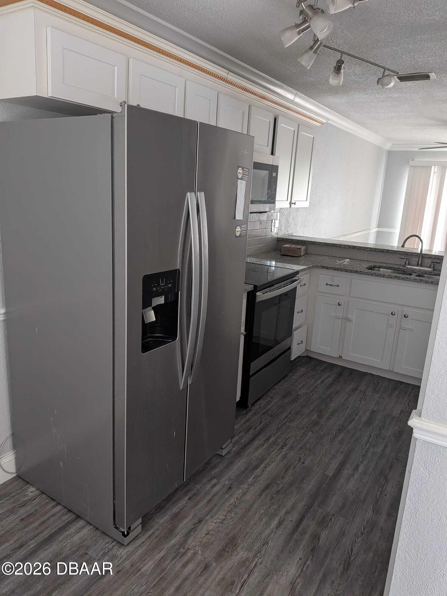480 Reed Canal Road, Unit 57 South Daytona, FL 32119 - Photo 3 of 10 a kitchen with stainless steel appliances a refrigerator and wooden floor
