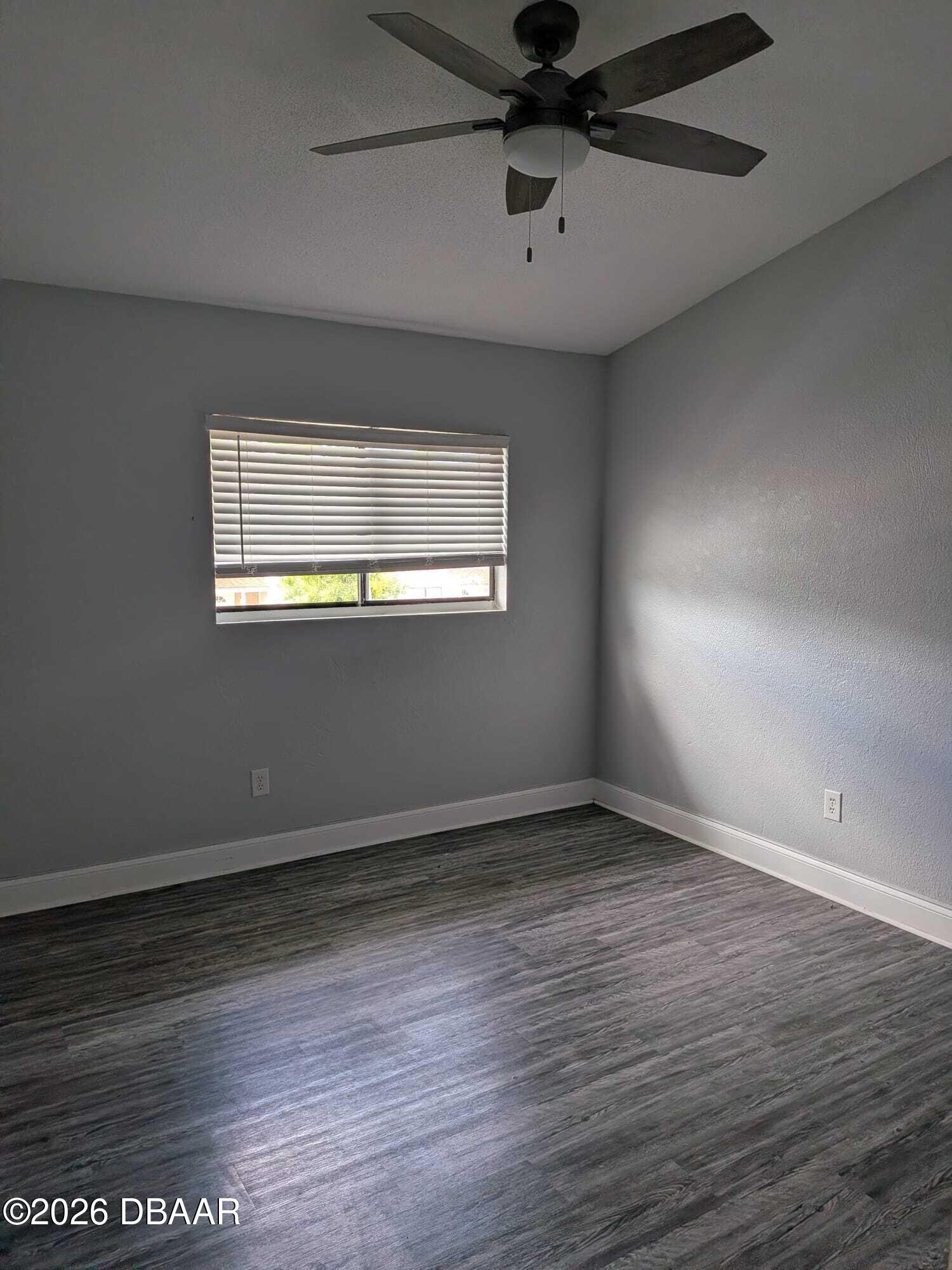 480 Reed Canal Road, Unit 57 South Daytona, FL 32119 - Photo 9 of 10 an empty room with wooden floor fan and windows