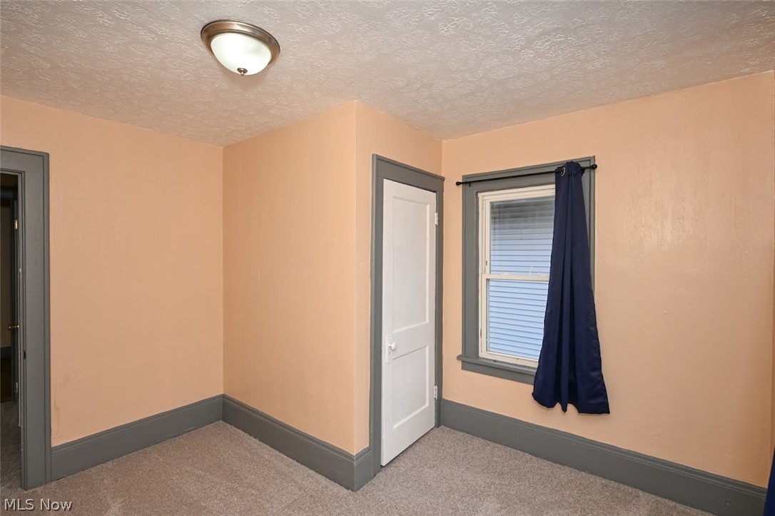 77 West Mildred Avenue Akron, OH 44310 - Photo 19 of 40 Carpeted spare room featuring a textured ceiling