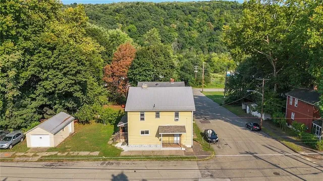 an aerial view of a house with yard and mountain view in back