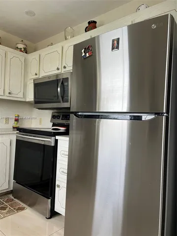 a kitchen with stainless steel appliances and refrigerator