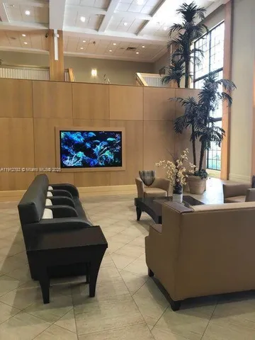 a living room with couches and a potted plant