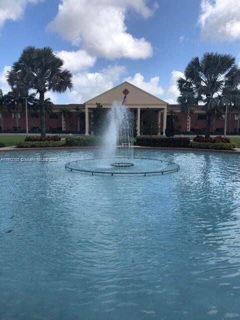 155 Suffolk F, Unit D Boca Raton, FL 33434 - Photo 20 of 22 a front view of a house with garden