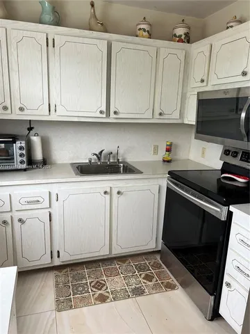 a kitchen with stainless steel appliances white cabinets and a sink
