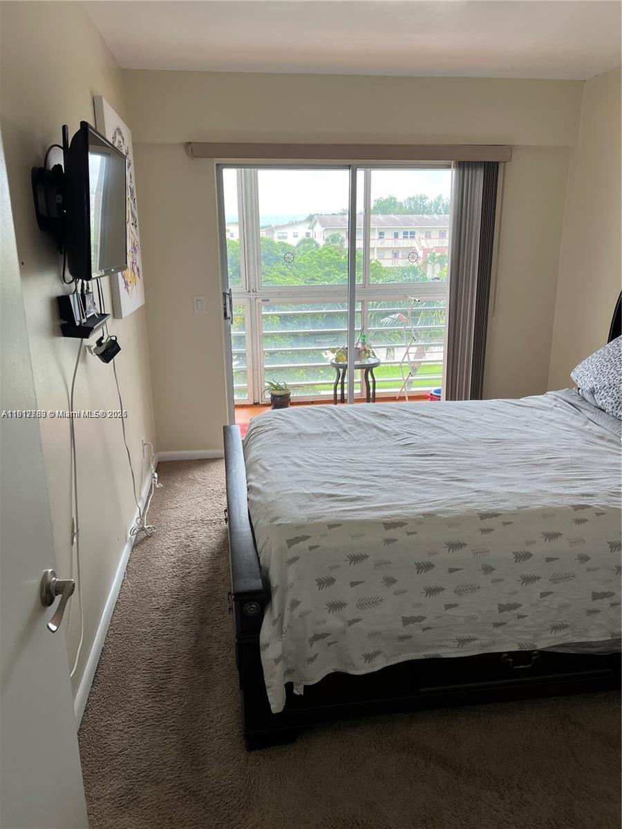 155 Suffolk F, Unit D Boca Raton, FL 33434 - Photo 9 of 22 a bed sitting in a bedroom next to a window