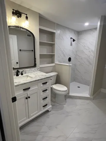 a bathroom with a sink a toilet and shower
