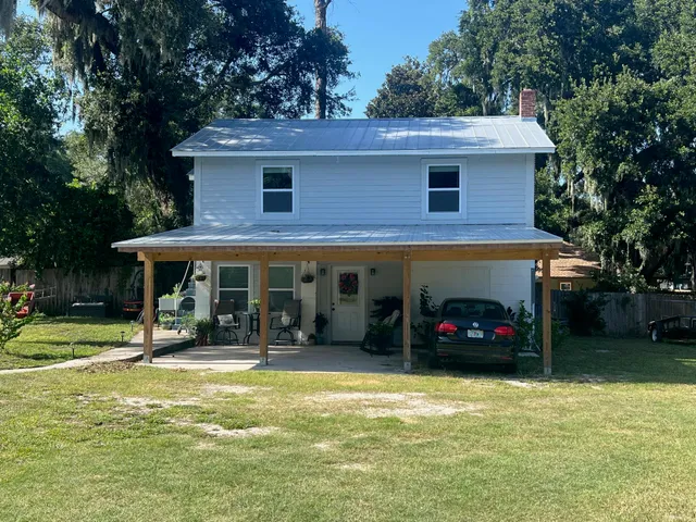 a view of a house with a patio and a yard