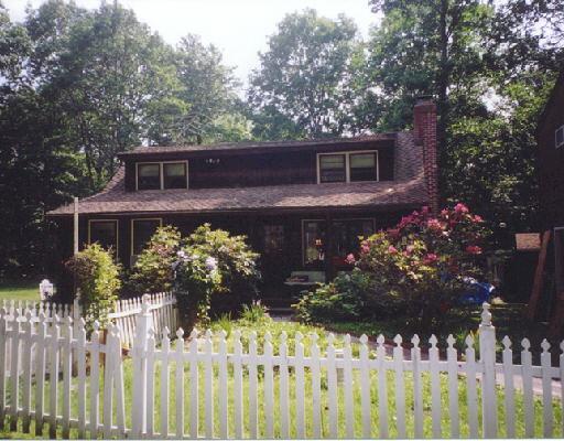 16 Wood Road Redding, CT 06896 - Photo 1 of 1 a front view of a house with a yard covered with flower plants