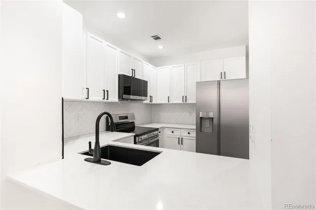 a kitchen with stainless steel appliances a refrigerator sink a stove a microwave and cabinets