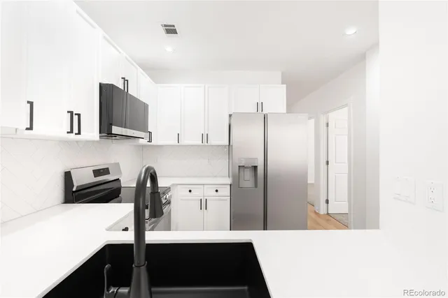 a kitchen with stainless steel appliances a refrigerator and a stove top oven