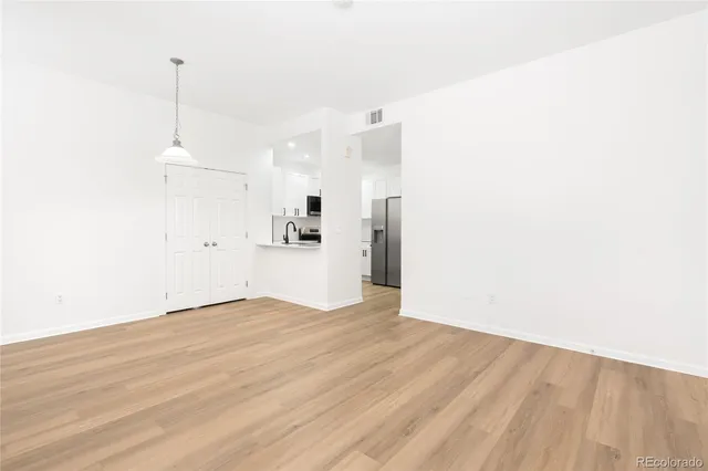 a view of a kitchen with wooden floor and a window