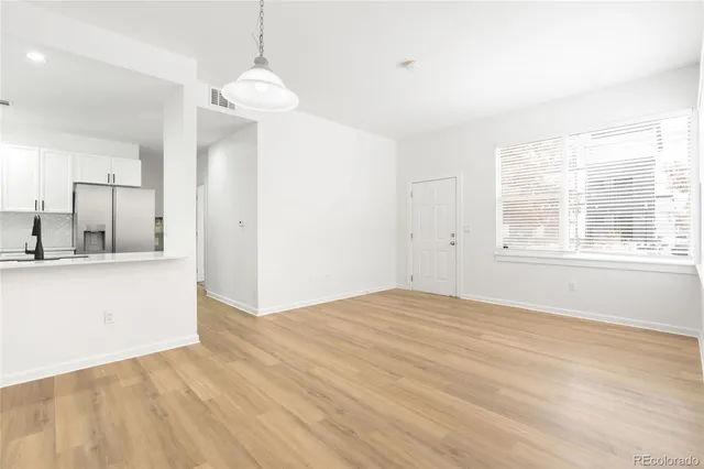 a view of a kitchen with wooden floor and a window