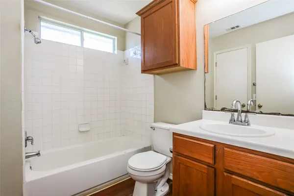 a bathroom with a granite countertop toilet sink and mirror