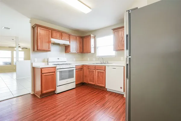 a kitchen with a white cabinets and wooden floor