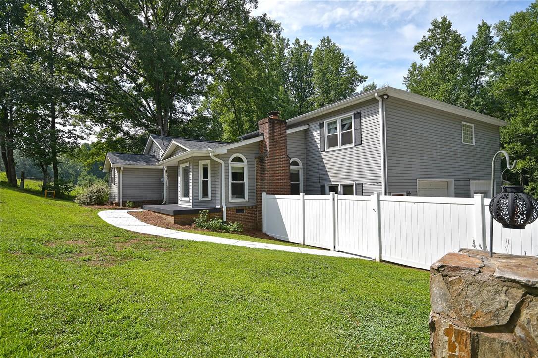 197 Deer Creek Road Easley, SC 29640 - Photo 4 of 50 A graceful paved path guides to a charming residence featuring a brick chimney and inviting curb appeal.
