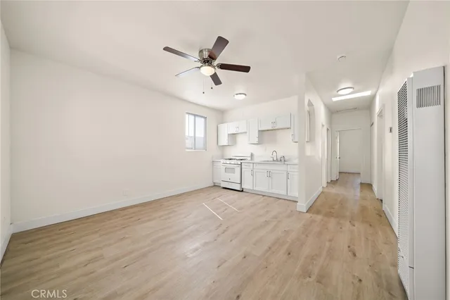 a view of a kitchen with wooden floor and electronic appliances