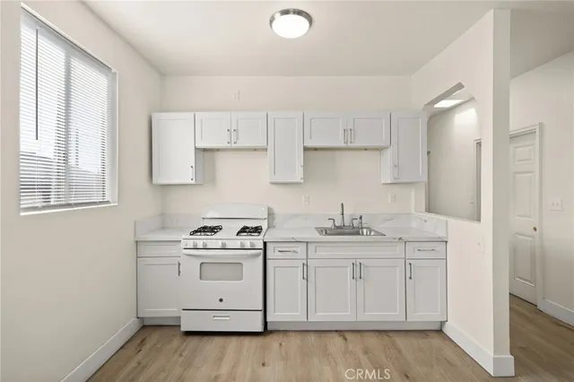 a kitchen with stainless steel appliances granite countertop a sink stove and cabinets