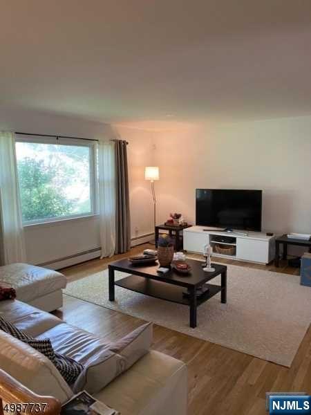 552 Stevens Avenue Ridgewood, NJ 07450 - Photo 4 of 43 a living room with furniture a flat screen tv and a large window