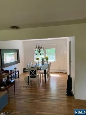 a view of a dining room with furniture a chandelier and wooden floor