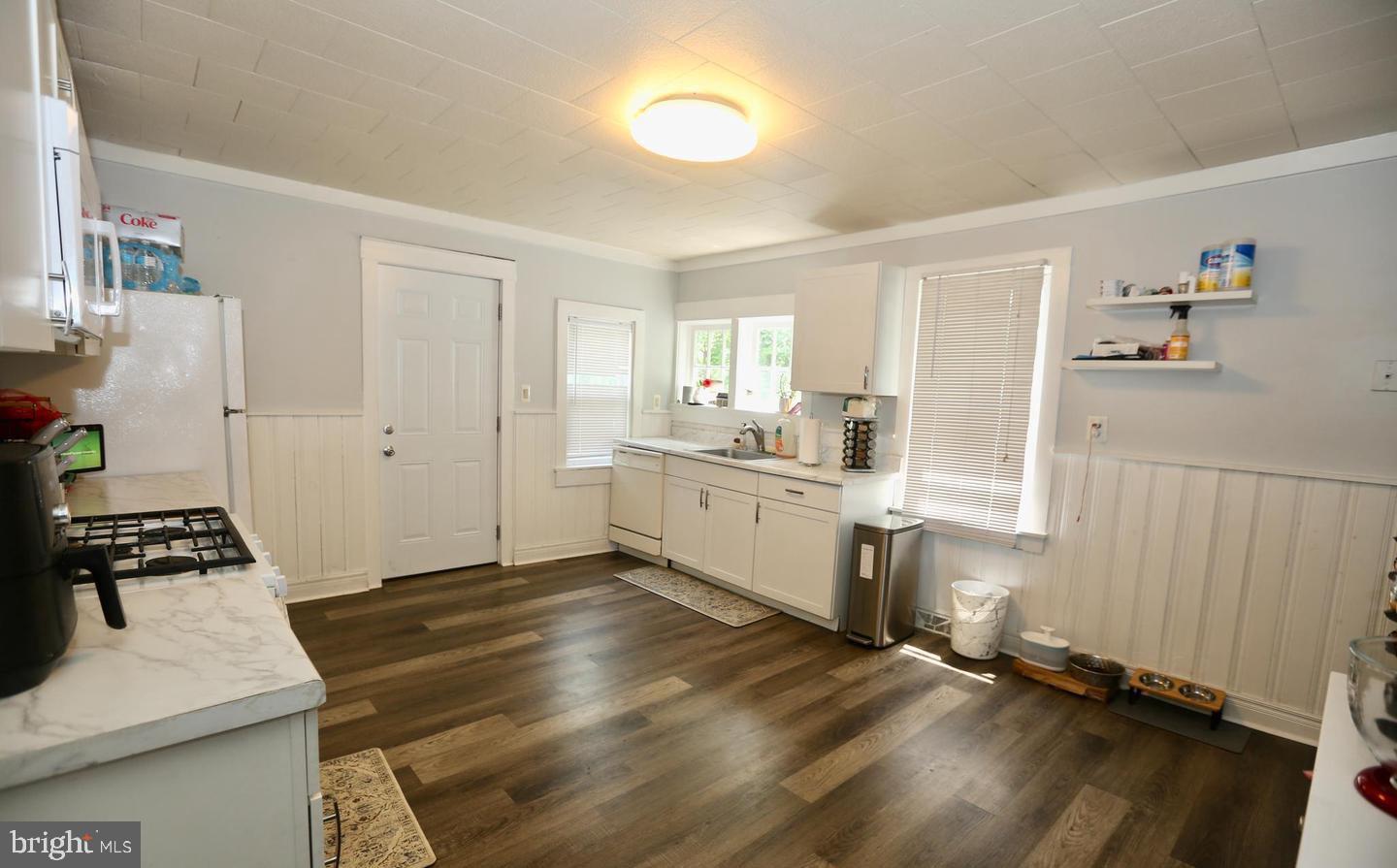 116 Ellis Street Glassboro, NJ 08028 - Photo 6 of 10 a kitchen with granite countertop a stove a sink and white cabinets with wooden floor