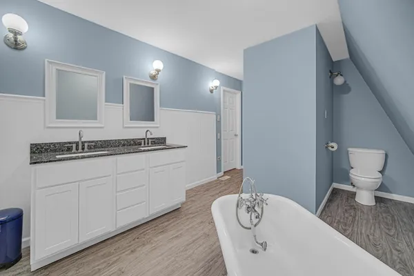 a en suite bathroom with a granite countertop toilet and a sink