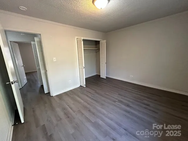 an empty room with wooden floor and closet