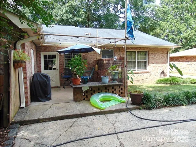 a view of a patio with table and chairs under an umbrella