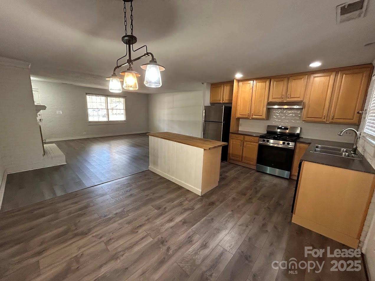 3312 Circles End Circle Charlotte, NC 28226 - Photo 4 of 22 a kitchen with granite countertop wooden floors wooden cabinets and stainless steel appliances