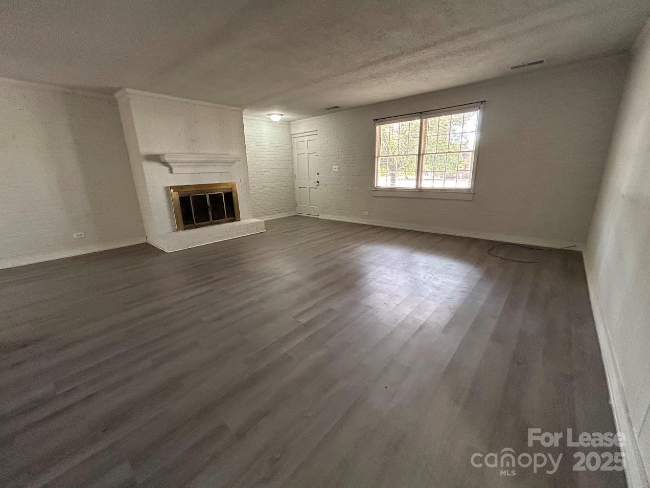 3312 Circles End Circle Charlotte, NC 28226 - Photo 7 of 22 an empty room with wooden floor fireplace and windows