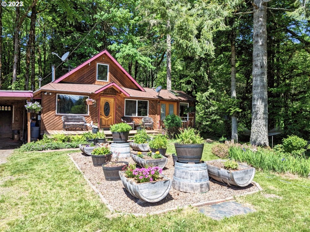 72769 Snowdon Road Rhododendron, OR 97049 - Photo 1 of 48 a front view of a house with a garden and patio