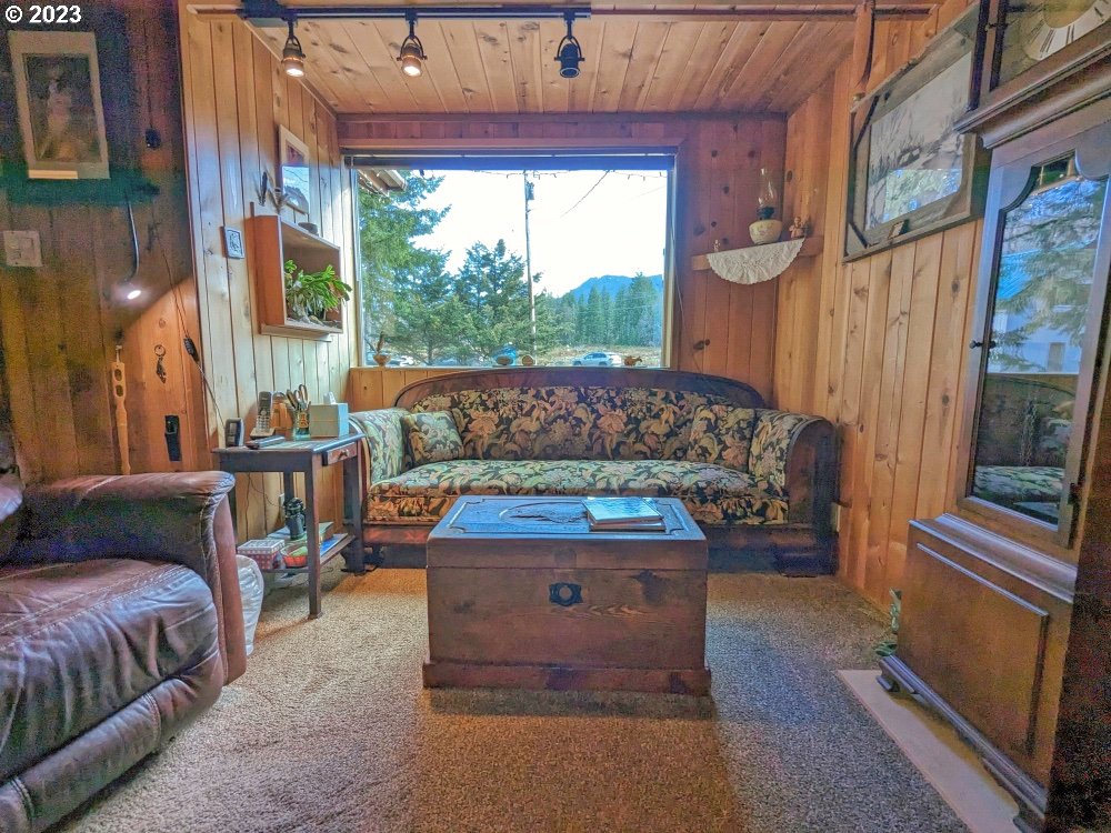 72769 Snowdon Road Rhododendron, OR 97049 - Photo 14 of 48 a living room with a couch a fireplace and a large window