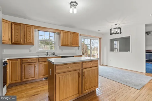 a kitchen with granite countertop a sink cabinets and wooden floor