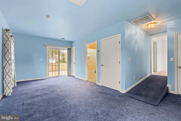 an empty room with windows and closet